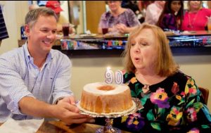CANDLE IN THE WIND--With North Carolina Lieut. Governor Dan Forest looking on, Betty extinguishes the 90 candles on her birthday cake. Photo by Hobart Jones.